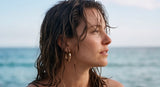 Woman with wet hair looking towards the ocean wearing Holly Hoops earrings from Delani Jewelry