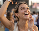 Close-up of woman smiling outdoors wearing gold Azizi Hoops chain earrings — tarnish-proof, waterproof, backed by Delani's lifetime color guarantee