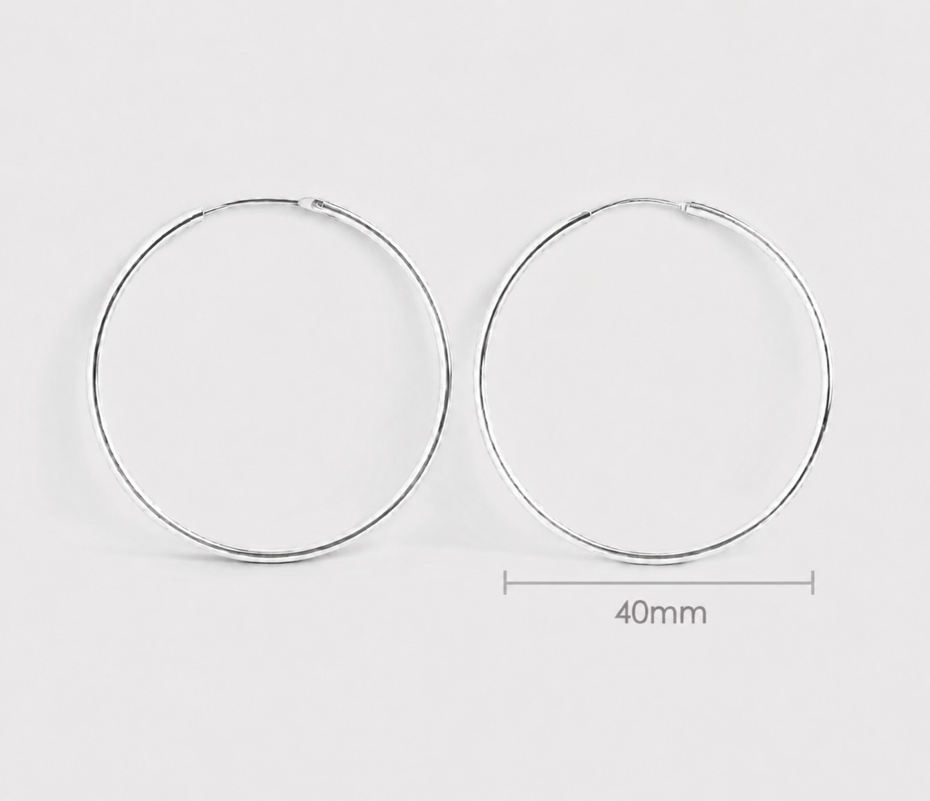 Frankie silver hoop earrings on a light gray background with a measurement label indicating 40mm from Delani Jewelry