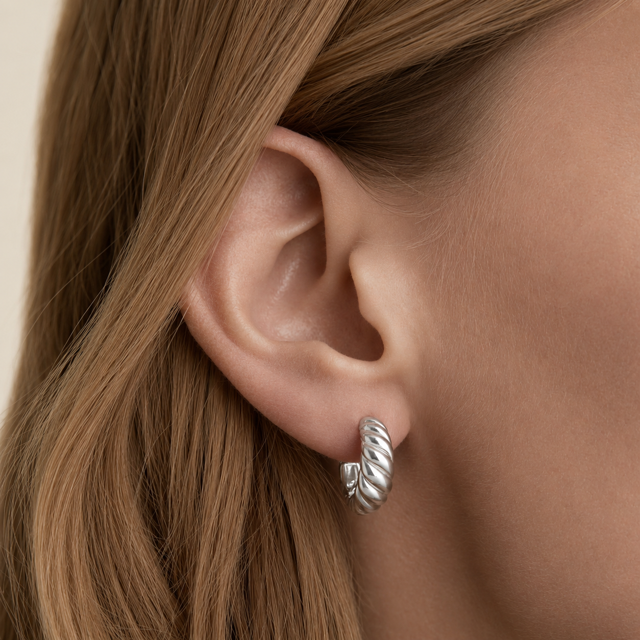Delani Jewelry Kala Hoop Earrings in waterproof, tarnish-proof silver PVD stainless steel with a lifetime color guarantee, featuring a chunky twisted hoop design.
