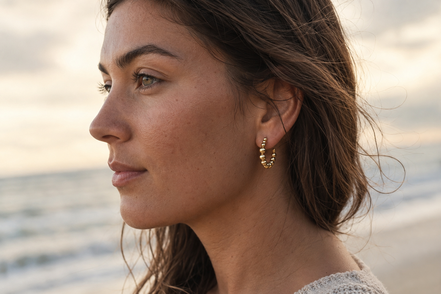 The design is gold and looks like bubbles in ascending sizes from the center. These are the Kendall Earrings with that are waterproof, tarnishproof with a lifetime color guarantee jewelry from Delani Jewelry.