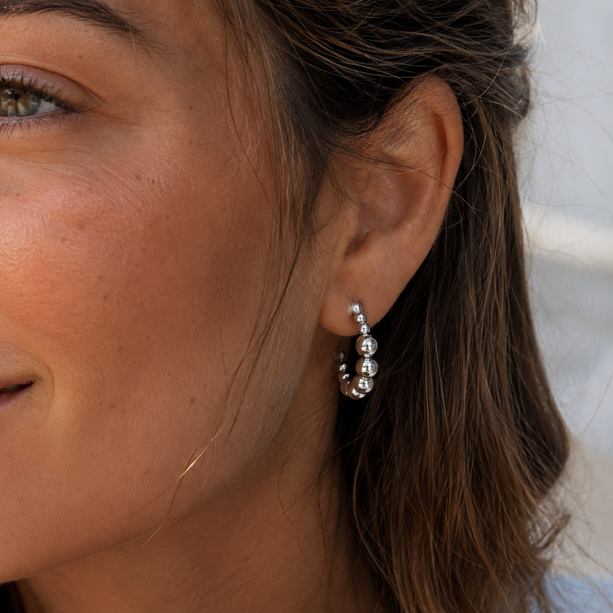 The design is silver and looks like bubbles in ascending sizes from the center. These are the Kendall Earrings with that are waterproof, tarnishproof with a lifetime color guarantee jewelry from Delani Jewelry.