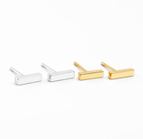 Gold and silver bar stud earrings from Delani Jewelry featuring sleek geometric rectangular studs with a polished finish, perfect for first, second, and third lobe piercings. Named Namaari Studs