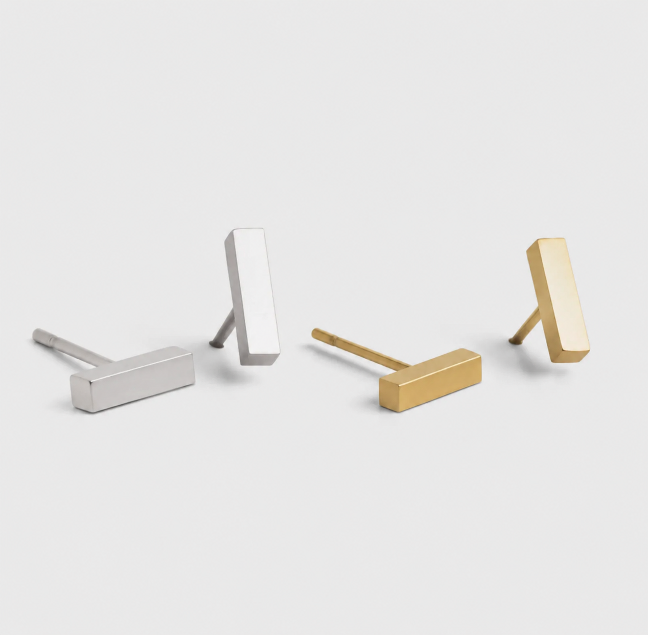 Delani Jewelry minimalist bar stud earrings in gold and silver, polished rectangular earrings displayed side by side for modern everyday jewelry styling. Named Namaari Studs