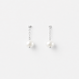 Minimalist product photo of Delani Jewelry Nubia Short Pearl Earrings in silver with luminous freshwater pearls. Tarnish-free, waterproof earrings backed by a lifetime color guarantee.