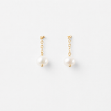 Product image of Delani Jewelry Nubia Short Pearl Earrings in gold with classic freshwater pearl drops. Tarnish-free, waterproof stainless steel earrings with a lifetime color guarantee.
