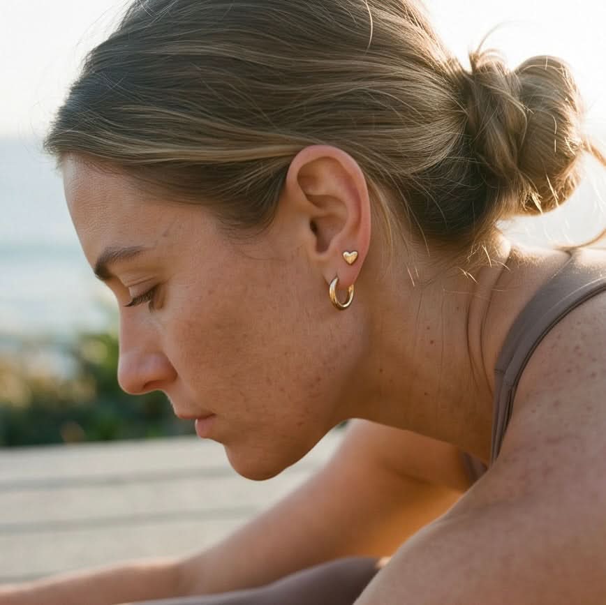 Waterproof gold heart stud earrings by Delani Jewelry paired with gold hoops, tarnish-proof stainless steel jewelry with a Lifetime Color Guarantee for everyday wear.