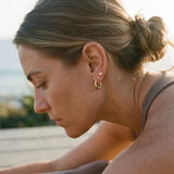 Waterproof gold heart stud earrings by Delani Jewelry paired with gold hoops, tarnish-proof stainless steel jewelry with a Lifetime Color Guarantee for everyday wear.