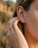 Close-up of Delani Jewelry gold heart stud earrings, waterproof and tarnish-proof stainless steel earrings with a Lifetime Color Guarantee for effortless everyday style.