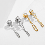 Shyla chain drop earrings by Delani Jewelry in gold and silver with one-stone and three-stone bezel-set designs. Waterproof, tarnish-proof, hypoallergenic earrings with a lifetime guarantee.Mismatched stones numbers create a drama and appeal unique to the Shyla Earrings. 