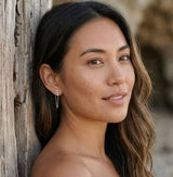 Minimalist silver Shyla chain drop earrings with bezel-set crystal and fine chain accent from Delani Jewelry. Waterproof, tarnish-proof, hypoallergenic earrings with a lifetime guarantee. Mismatched stones numbers create a drama and appeal unique to the Shyla Earrings. 
